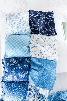 the blue and white quilts are laid out on top of each other in rows