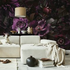 a dog is sitting on a couch in front of a floral wallpaper with purple flowers