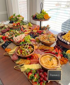 a table filled with lots of different types of foods and cheeses on top of it