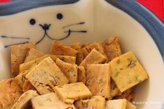 a bowl full of crackers with a cat's face painted on the side