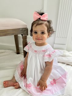 A dress that is meant to be in your little's closest! The prettiest hand-embroidered bows with a delicate eyelet make our Bella Bow Dress a must-have! Clothing Care Instructions: Machine wash gentle. Do not bleach. Tumble dry delicate at low heat. Iron at medium. If the item that you are ordering has red or another bright color in it next to a white or other light color fabric please use a Shout color catcher for the first few washes to avoid bleeding. Follow us on Instagram @thelillieandlilahshop for shop discounts and updates! Embroidered Bows, Pink Bow Dress, Hand Smocked Dress, Heirloom Dresses, Baby Faces, Foto Baby, Heirloom Sewing, Bow Dress, Baby Wedding