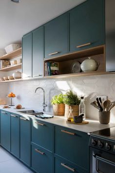 a kitchen filled with lots of green cabinets and counter top space next to an oven