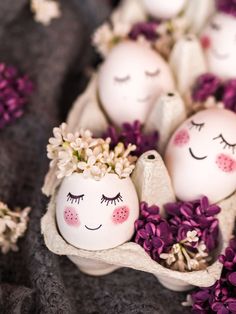 some eggs with faces painted on them and flowers