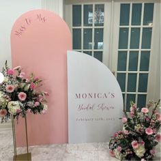 two tall vases filled with flowers sitting next to a sign that says monica's bridal affair