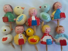 a group of small toy figurines sitting next to each other on toothpicks