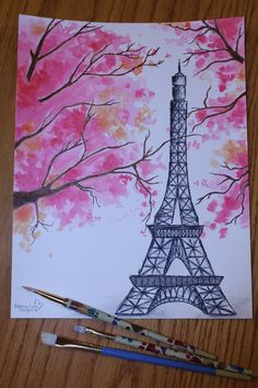 the eiffel tower is painted with watercolors on paper and paintbrushes