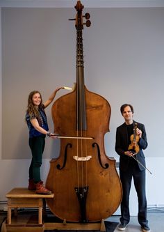 two people standing next to a large instrument