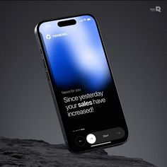 an iphone displaying the message's screen on top of a rock in front of a dark background