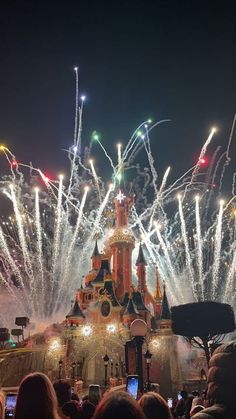 fireworks are lit up in the sky above a castle