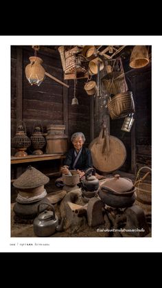 an old woman sitting in a room filled with pots and pans