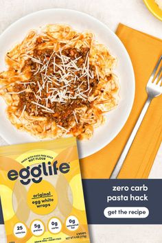 a plate of pasta with cheese on it next to an egglite packet and fork