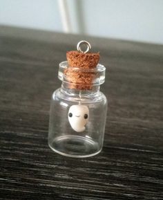 a small glass jar with a tiny face in it