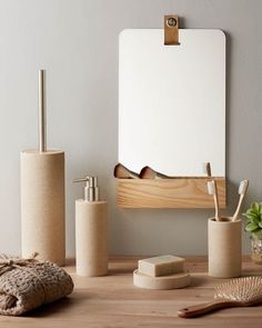 a wooden table topped with bathroom accessories and a white board on the wall behind it