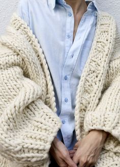 a person wearing a white sweater and blue shirt