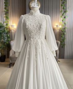 a white wedding dress on display in a room