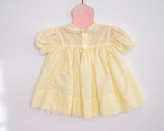 A sweet frock for a sweet little girl. This bright and cheery yellow dress has a crinolen layer sewn into the skirt. It features a sweet floral embroidery on the top and lace details. Approximately size 6-12 months, please see measurements below for best fit. Vintage Yellow dress Approximately 6-12 months Measurements: Shoulder to shoulder: 8 inches, chest 9.5 inches Has some brown lines/spots, pictured As with all vintage, we inspect each piece to determine any issues but we can not guarantee w Vintage Yellow Dress, Retro Yellow Cotton Dress, Baby Girl Yellow Dress, Vintage Baby Dresses Summer, Yellow Vintage Dress, Spring Vintage Cotton Dress With Doll Collar, Girls Yellow Dress, Baby Girl Yellow, Vintage Toddler Dress