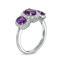 Balance shimmer and color with this oval bright purple amethyst and white lab-created sapphire frame three-stone ring - a glamourous look to top off your evening attire. Crafted in sterling silver This design glistens with a trio of oval-shaped purple amethyst. A 7.0 x 5.0mm center stone flanked by a pair of smaller side stones White lab-created sapphires surround each stone in a shimmering frame. Oval Purple Diamond Ring With Gemstone Accents, Purple Oval Brilliant Cut Ring, Elegant Three Stone Amethyst Promise Ring, Elegant Amethyst Three-stone Anniversary Ring, Oval Amethyst Three-stone Jewelry, Oval Three-stone Amethyst Jewelry, Oval Three Stone Amethyst Ring, Fine Jewelry, Classic Three Stone Purple Jewelry, Oval Three-stone Amethyst Ring