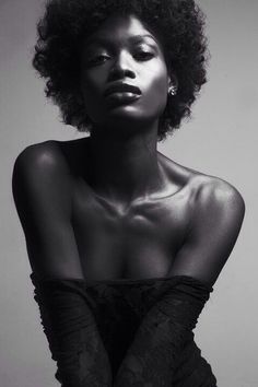 a woman with an afro is posing for a black and white photo, she has her hands on her hips