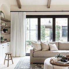 a living room filled with furniture and lots of windows