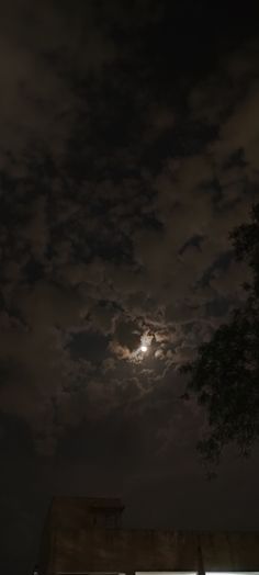 the moon is shining brightly in the night sky over a building with windows on it