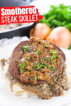 a steak skillet on top of mashed potatoes with parsley garnish