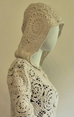 a mannequin wearing a white crochet sweater with hood on it's head