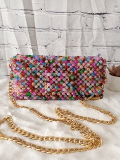 Carry a little extra sparkle wherever you go with this stunning beaded bag. Bags are 100% handmade. Dimension: Width: 21.5cm Height: 11cm Depth: 6cm The bag comes with a chain handle which measures 110cm. Feel free to contact me for any questions. Multicolor Crossbody Shoulder Bag For Party, Trendy Beaded Clutch Shoulder Bag, Trendy Beaded Evening Bag, Trendy Handheld Beaded Evening Bag, Trendy Handmade Shoulder Bag For Party, Multicolor Rectangular Evening Bag, Trendy Multicolor Clutch Evening Bag, Multicolor Square Shoulder Bag For Evening, Trendy Beaded Evening Bag As Gift