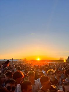 a large group of people standing in front of the sun at an outdoor concert or festival