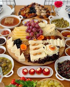 a wooden table topped with lots of different types of foods and desserts on plates