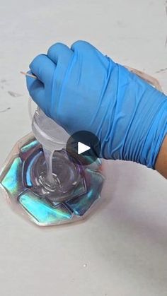 a person in blue gloves is using a machine to remove the glass from the floor