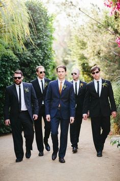 a group of men in suits walking down a path