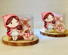 two little figurines sitting on top of wooden slices