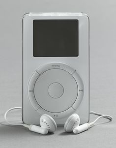 an mp3 player with headphones on top of it, in front of a gray background