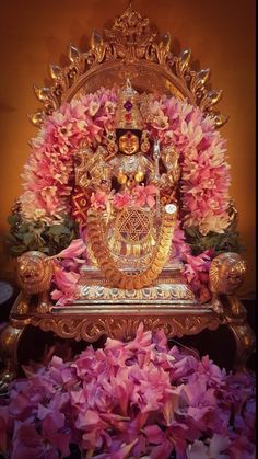 the statue is surrounded by pink flowers