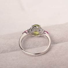 * The delicate ring displays peridot as main stone. The cluster side stones make the ring similar to the blooming flower . For who wearing this special & delicate ring, will shine like a goddess. ◆ Production Description: Main stone Type: Peridot Main Stone Shape: Oval Cut Main Stone Size: 6*8mm (1.33ct) Side stone: CZ & Ruby Metal: 925 Sterling silver - Other options available in the drop down menu ◆ Customization: √Free for Add Engraving √Other Metal Type Available √Other Gemstones &am Promise Ring With Peridot In Round Shape, Green Peridot Ring For Promise, Green Peridot Promise Ring, Elegant Three Stone Peridot Ring, Lime Green Gemstone Birthstone Ring For Anniversary, Green Oval Promise Ring, Lime Green Gemstone Promise Ring, Lime Green Gemstone Rings For Wedding, Lime Green Gemstone Wedding Rings