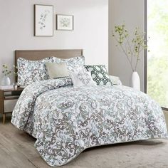 a bed in a room with a white and blue comforter