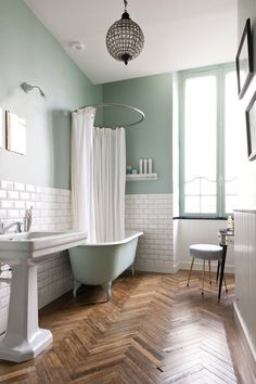 a bath room with a tub a sink and a window