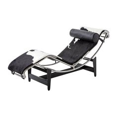 a black and white chaise lounge chair with cow hide rug on the backrest