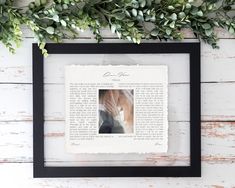 an old book page is framed in black and white with greenery on the wall