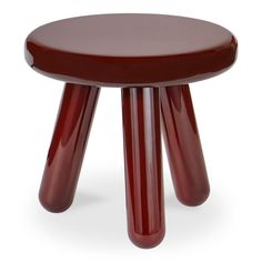 a small red stool with three legs and a wooden seat on the bottom, sitting in front of a white background