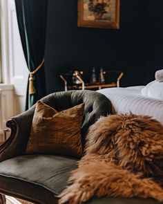 a couch with pillows on top of it next to a bed