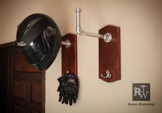 a motorcycle helmet mounted to the side of a wall with gloves hanging on it's hooks