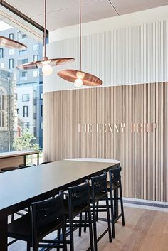 an empty table and chairs in front of a wall with wooden slats on it