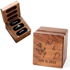 an open wooden box with three rings in it and the lid opened to show its contents