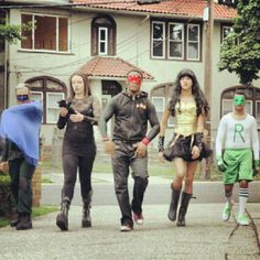 four people walking down the street in costumes