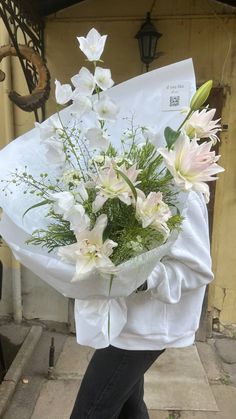 a woman holding a bouquet of white flowers