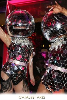 two women dressed in disco wear dancing at a party