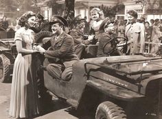 an old black and white photo of people riding in the back of a truck