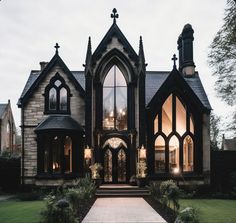 the entrance to a gothic - style house lit up at night with lights shining on it's windows