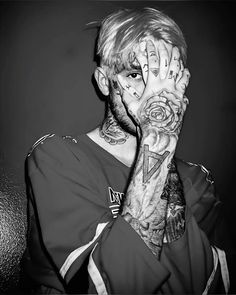 a man with tattoos covering his face and hands